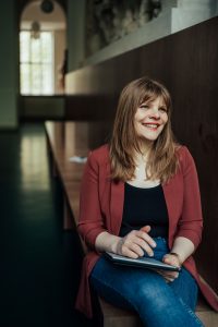 Das Bild zeigt die Dozentin und KI-Expertin Annemarie Michel in einem langen Flur.